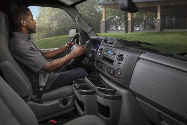 A man in the drivers seat of a 2023 Ford E-Series Cutaway