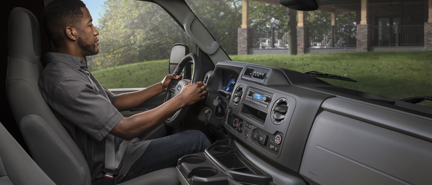 A man in the drivers seat of a 2024 Ford E-Series Cutaway