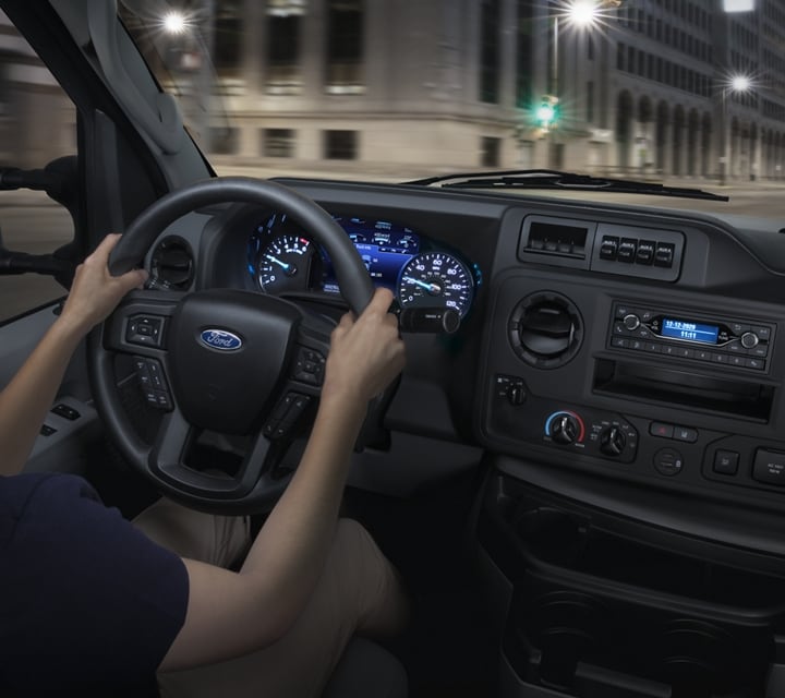 A woman in the drivers seat of a 2024 Ford E-Series