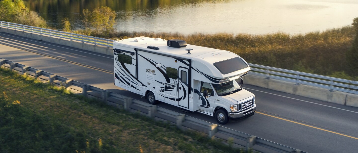 2024 Ford E-Series Cutaway with class C motorhome being driven near a large body of water