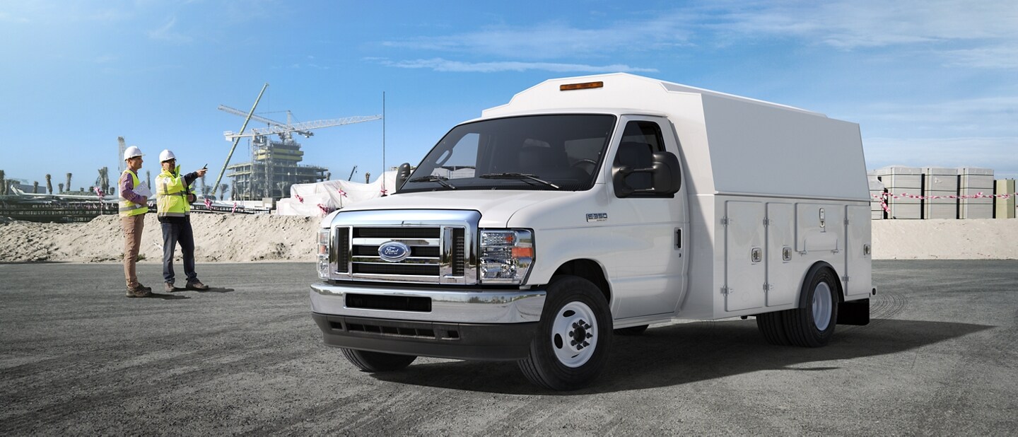 Dos trabajadores de la construcción cerca de una Ford E Series Cutaway 2024 con mejora de carrocería para contratistas