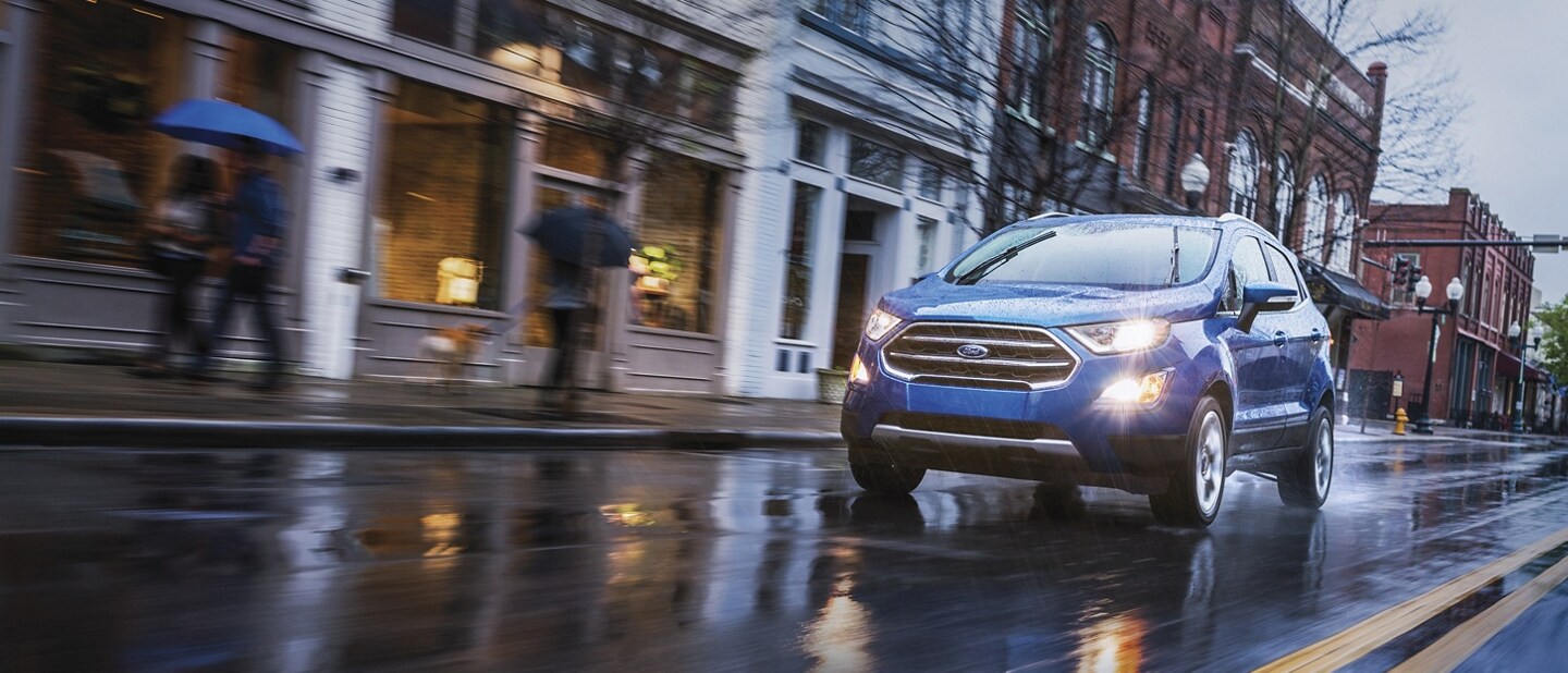 Una Ford EcoSport 2021 en Lightning Blue andando por una calle de ciudad mojada