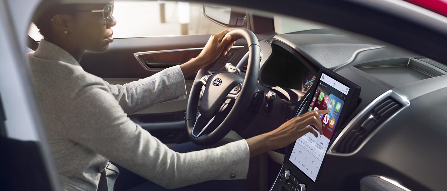Woman uses the 12-inch touchscreen in a parked 2022 Ford Edge