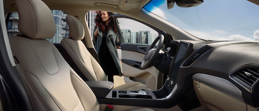Interior de una Ford Edge 2022 con una mujer sentada en el asiento del conductor.