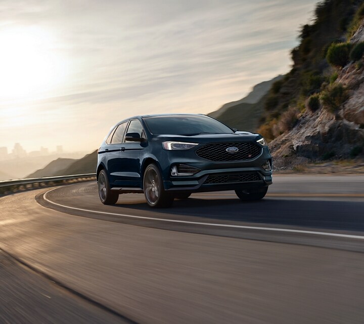 Una Ford Edge 2022 en Stone Blue andando por una autopista con curvas