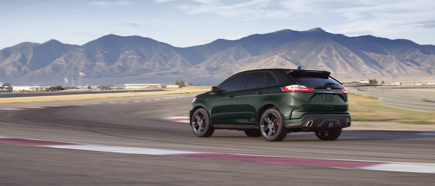 2022 Ford Edge in Forged Green being driving on a highway toward the mountains