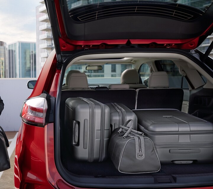 A woman beside a 2023 Ford Edge® with back hatch open full of luggage