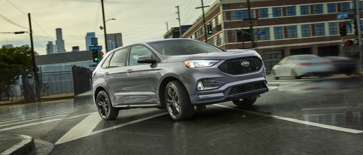 2024 Ford Edge® SUV in Iconic Silver being driven on a wet city street