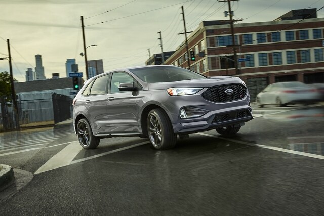 2024 Ford Edge® SUV in Iconic Silver being driven on a wet city street