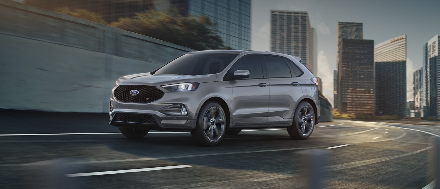 2024 Ford Edge® SUV in Iconic Silver being driven through a city