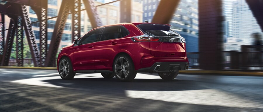 2024 Ford Edge® ST SUV in Race Red being driven across a bridge
