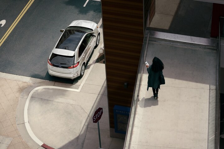 Woman on a walkway overlooking her 2024 Ford Edge® SUV parked on the street below