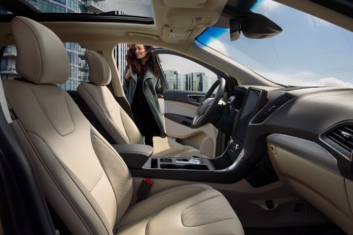 Interior of 2024 Ford Edge® Titanium model with a woman closing the driver side door