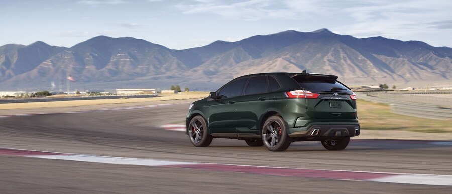 2024 Ford Edge® in Forged Green being driven down a city street