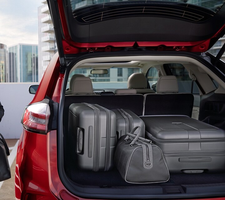 A woman beside a 2024 Ford Edge® with back hatch open full of luggage