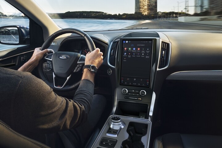 Interior of a 2024 Ford Edge® as a man drives and looks at interior console