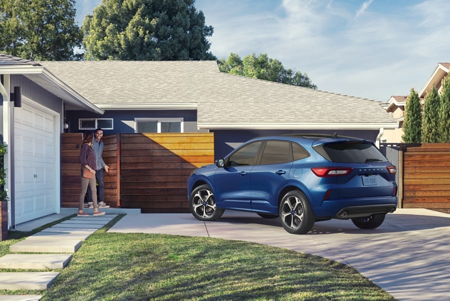 Una Ford Escape® 2023 en Atlas Blue en la entrada de una casa