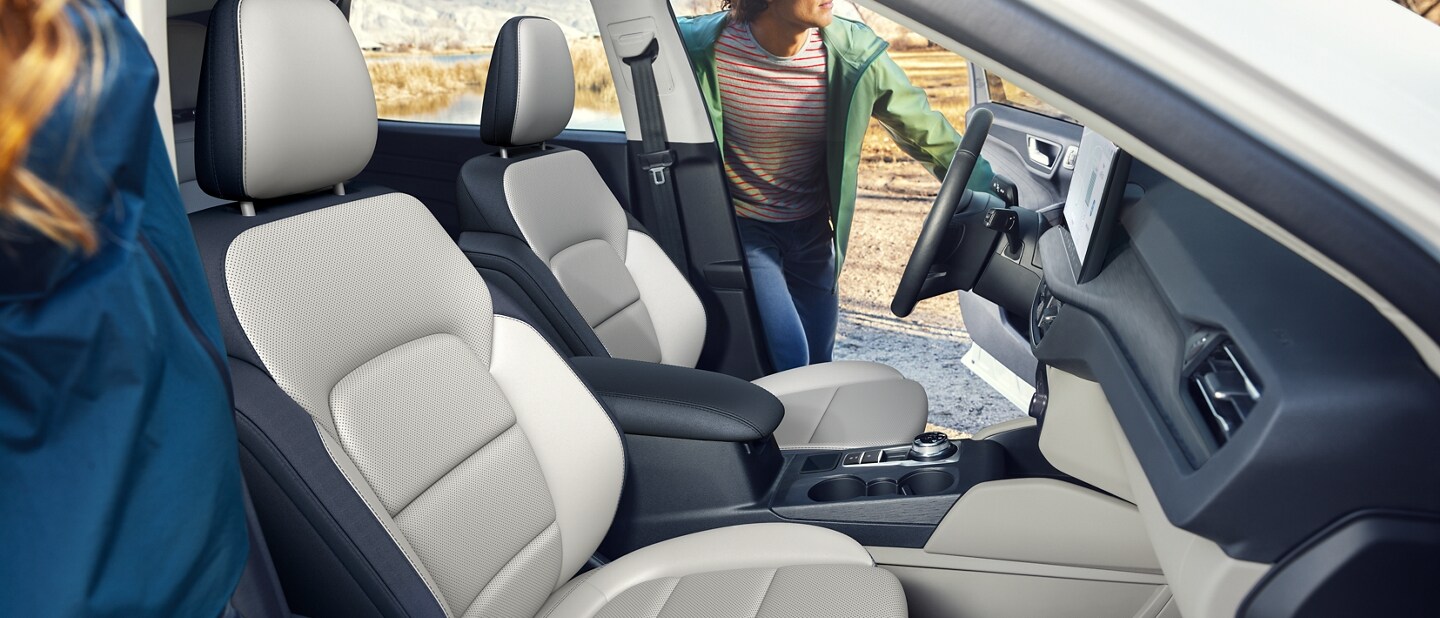 Vista interior de una Ford Escape® 2023 mientras dos personas comienzan a ingresar