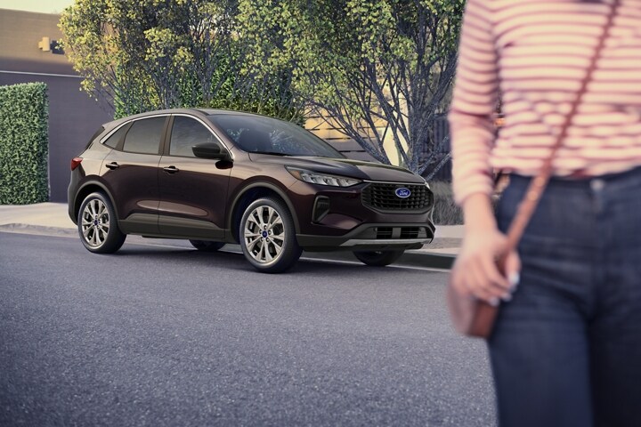 2023 Ford Escape® in Cinnabar Red parked on street next to house