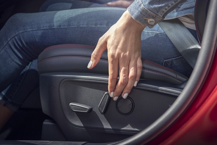 Interior shot of a 2023 Ford Escape® showing a woman operating the power seat control
