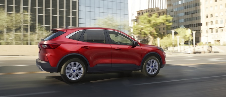 Una Ford Escape® 2023 en Rapid Red Metallic circulando por una calle urbana