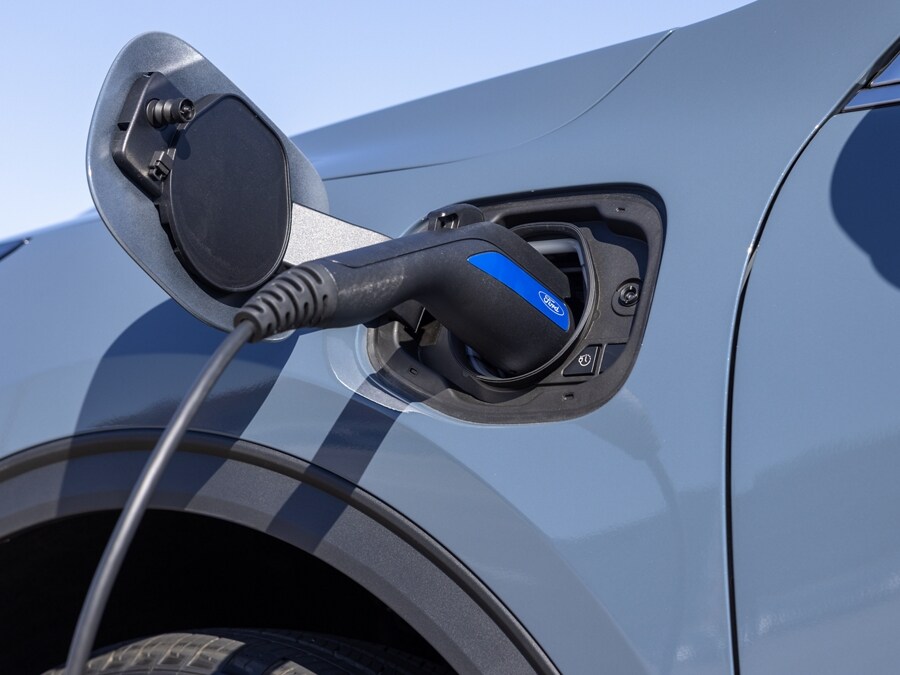 Close-up view of a charging cable plugged into the charge port of a hybrid 2024 Ford Escape