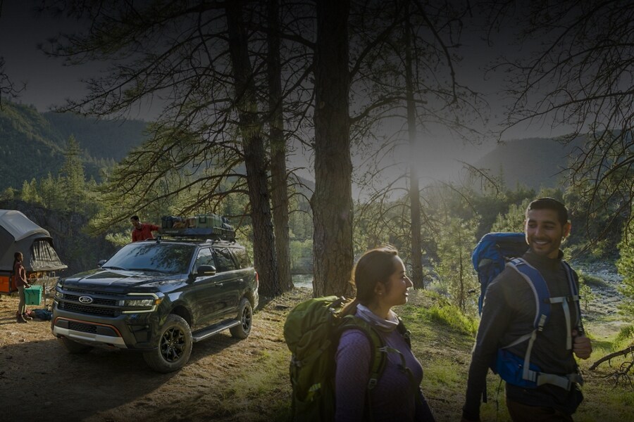 A 2023 Ford Expedition SUV parked at a campsite in the woods