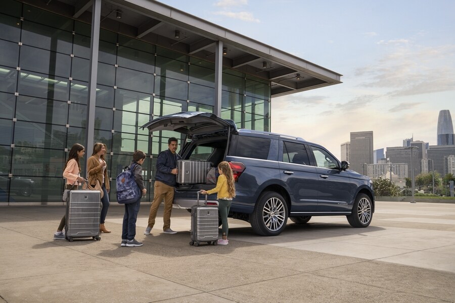 A family loading luggage into the rear of a 2023 Ford Expedition SUV