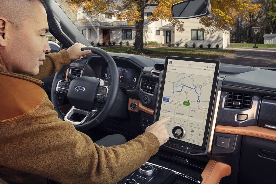 A man using the touchscreen inside a 2023 Ford Expedition SUV
