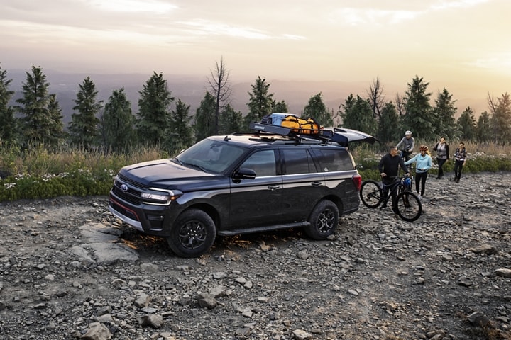 A 2023 Ford Expedition SUV parked on a rocky road with people around it