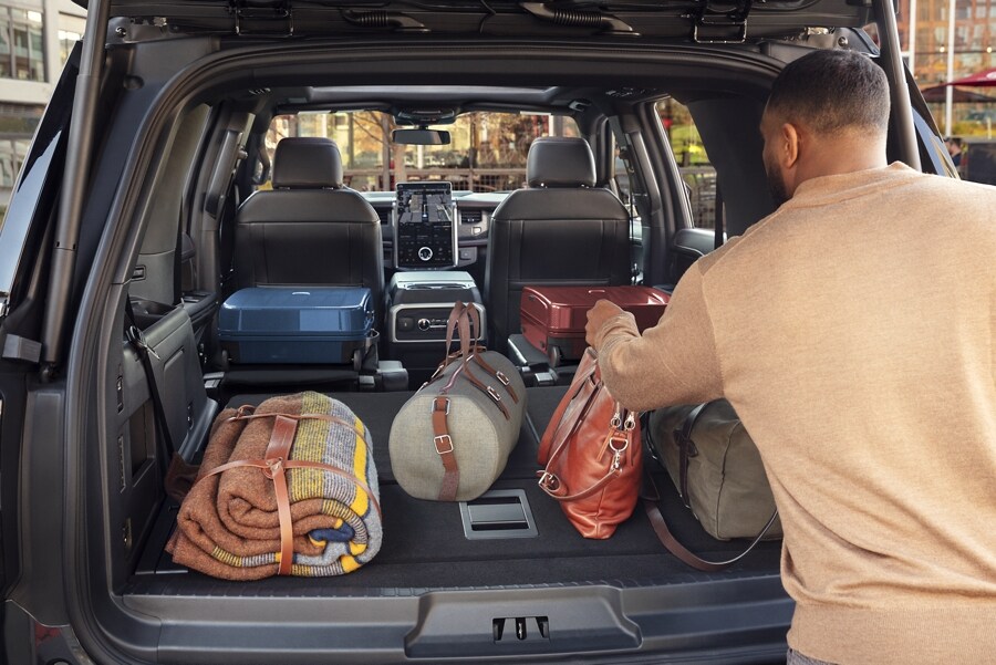 A man loading gear into the back of a 2023 Ford Expedition SUV