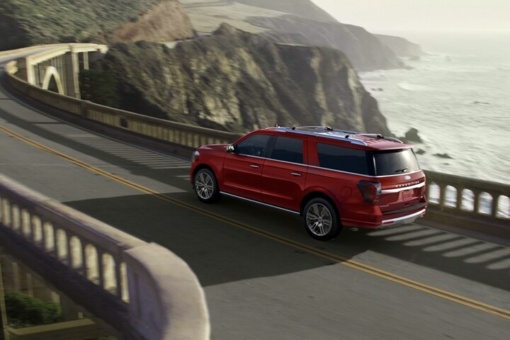 A 2023 Ford Expedition SUV driving across a bridge on a mountain road