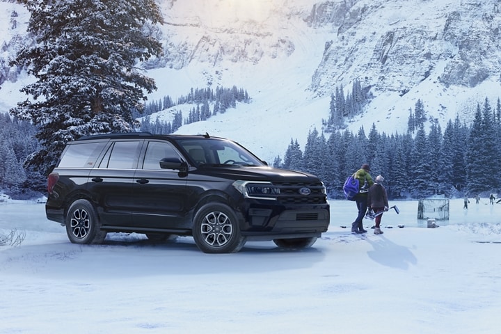 A 2024 Ford Expedition XL STX parked next to a group playing hockey on a frozen pond