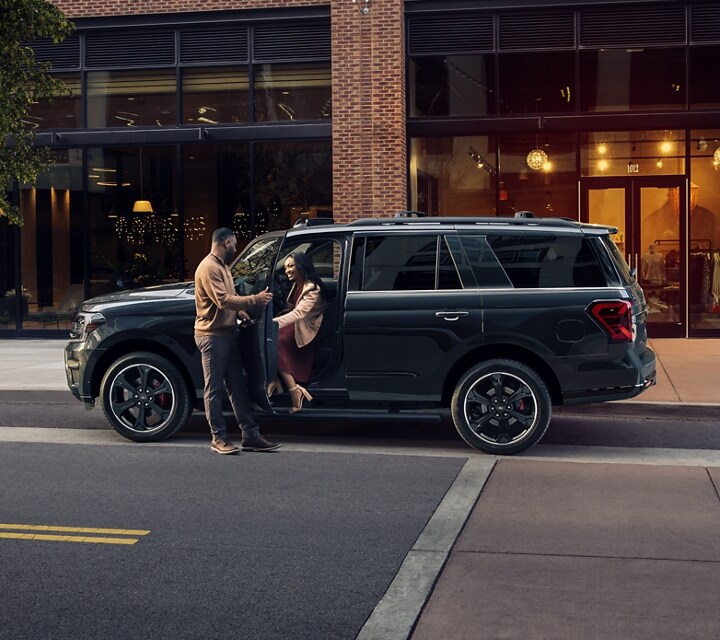 A man and woman couple getting out of a 2024 Ford Expedition on a trendy downtown city street