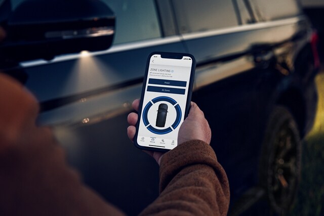 A person controlling Exterior Zone Lighting with the FordPass® smartphone app