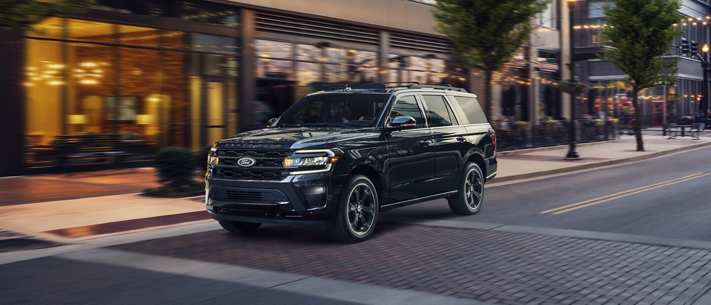 A 2024 Ford Expedition driving on a downtown city street