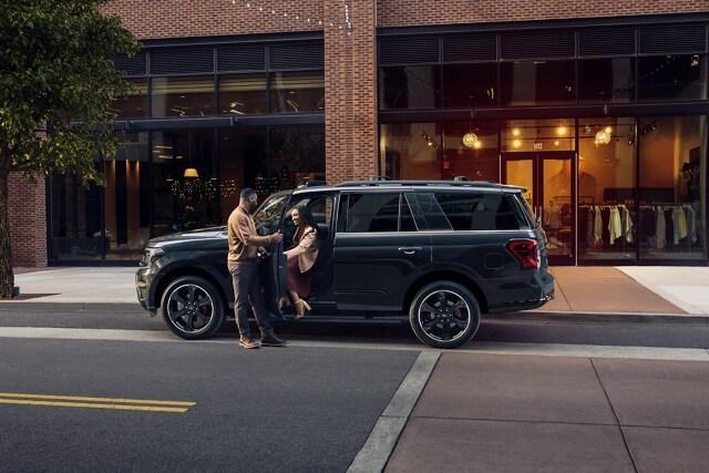 A man opening the door of a 2024 Ford Expedition SUV as a woman exits