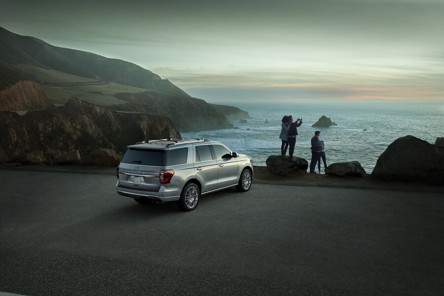 People taking photos of the ocean next to a 2024 Ford Expedition SUV