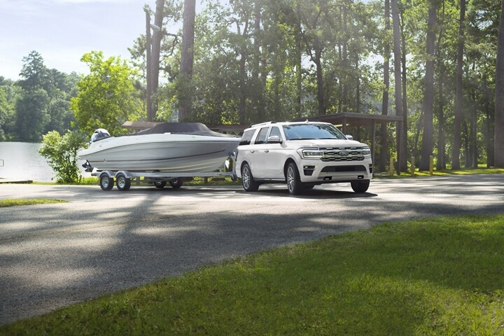 A 2024 Ford Expedition Platinum Max model towing a boat from a boat launch