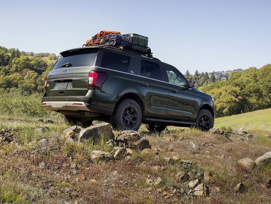 A 2024 Ford Expedition SUV driving over a rugged hillside trail