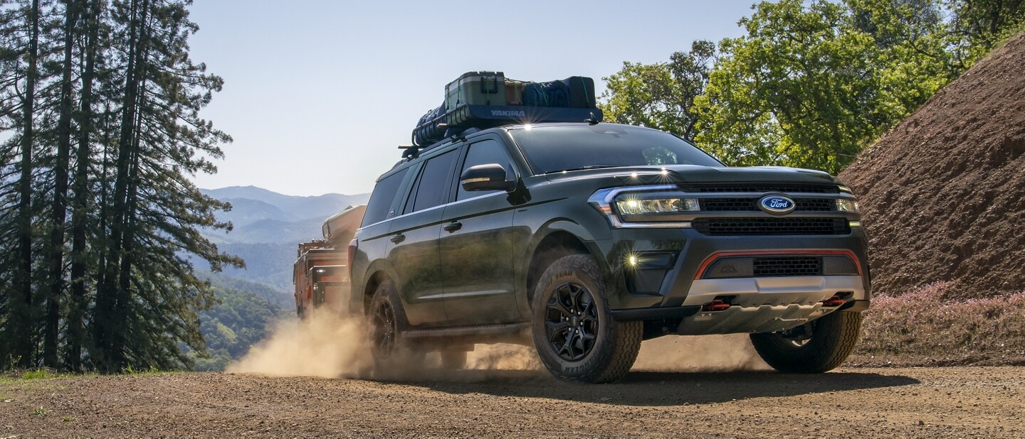 A 2024 Ford Expedition driving over rugged, sandy terrain