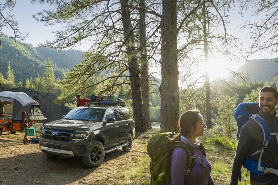 A 2024 Ford Expedition SUV parked at a campsite in the woods