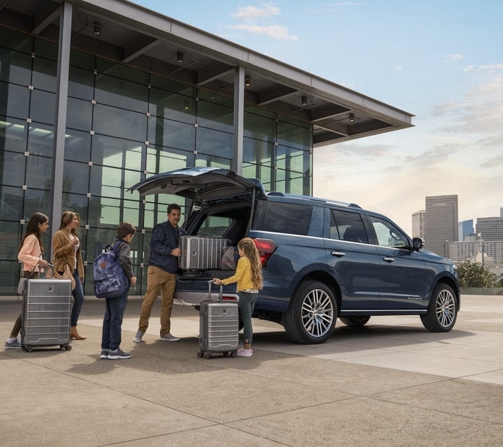 A 2024 Ford Expedition with its cargo space being loaded up with bags and luggage by a family at the airport