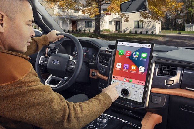 A man using the touchscreen inside a 2024 Ford Expedition SUV