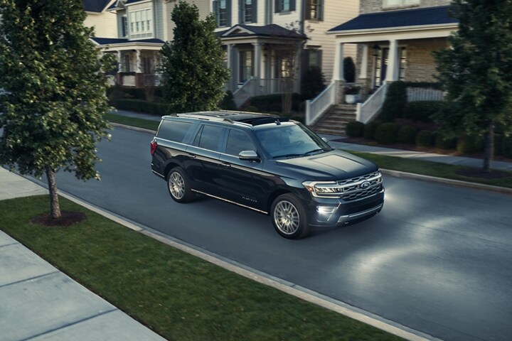 A 2024 Ford Expedition being driven at night time through a neighborhood
