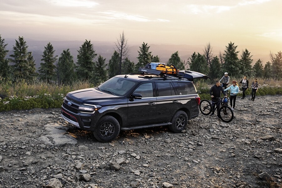 A 2024 Ford Expedition SUV parked on a rocky road near a body of water