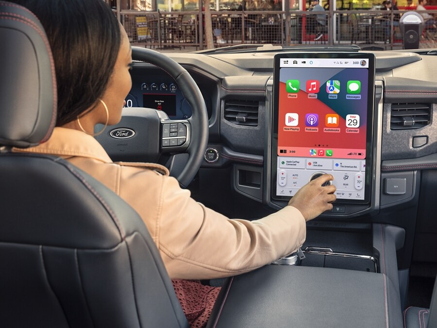 Close-up of a woman in the driver seat of a 2024 Ford Expedition SUV using the in-vehicle center LCD Touchscreen
