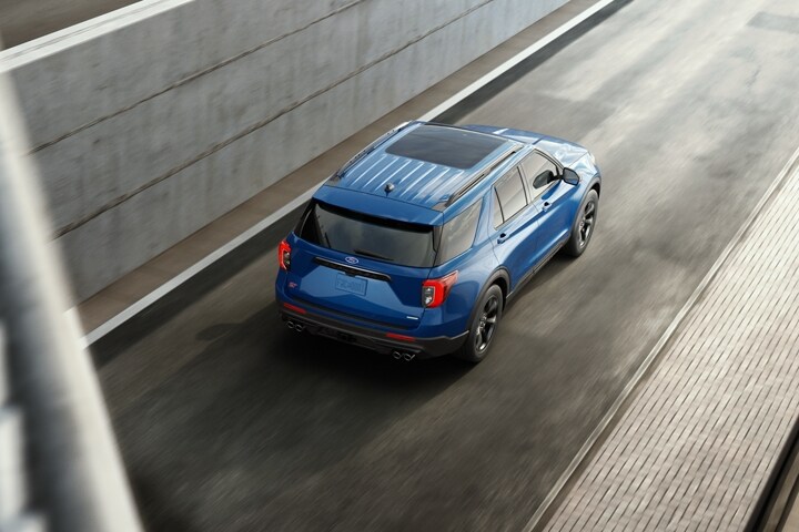 El modelo Ford Explorer® ST 2023 en Atlas Blue Metallic circulando por una calle urbana