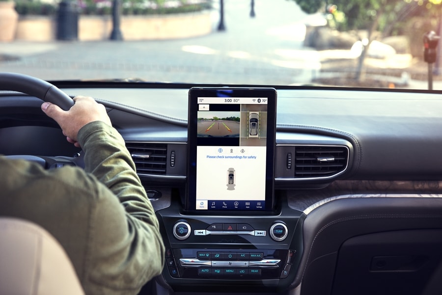 El interior de una SUV Ford Explorer® 2023 que muestra la pantalla táctil y una persona conduciendo