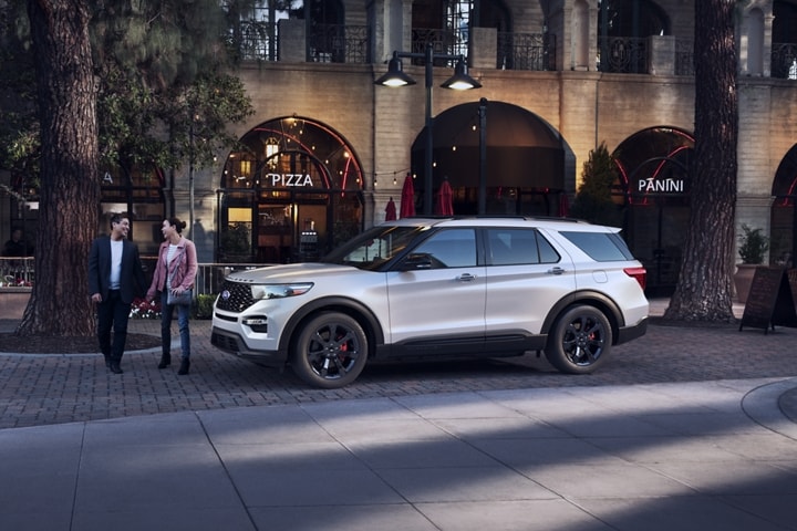 2023 Ford Explorer® ST model in Star White Metallic Tri-coat (extra cost color option) parked in the city near two people